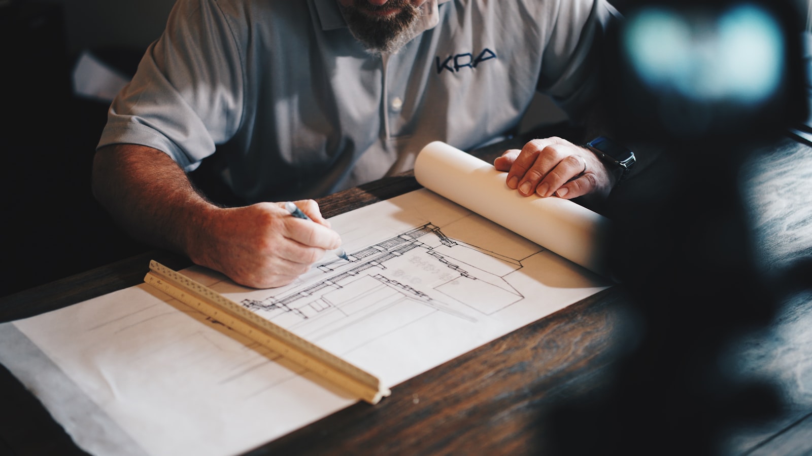 Contractor reviewing architectural blueprints with a ruler for a construction estimate