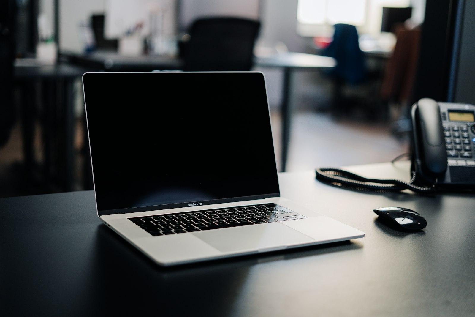Dedicated on-call answering desk with a laptop and business phone ready for emergency calls