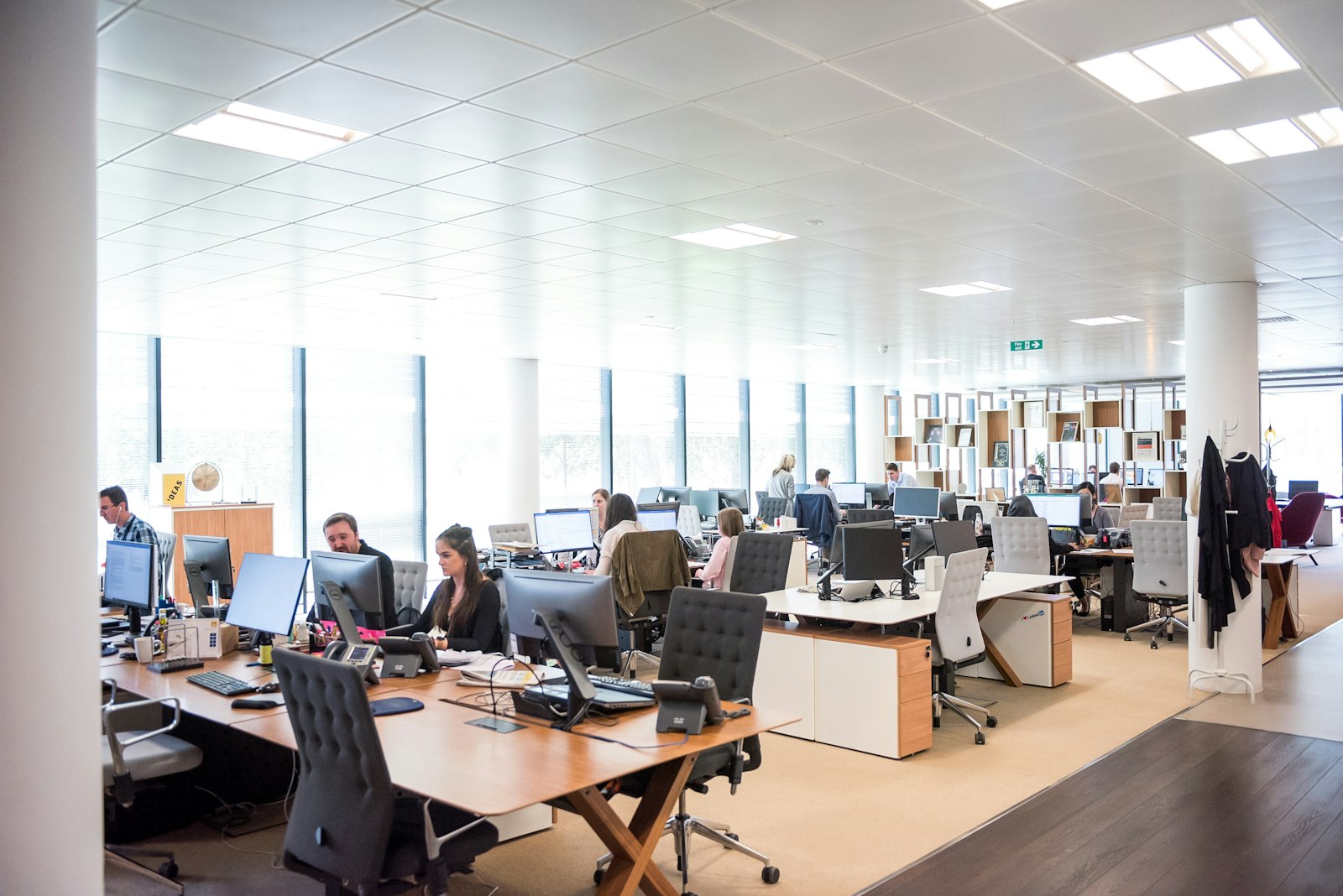 Modern open-plan office with United Answering Service agents at desks with phones and computers