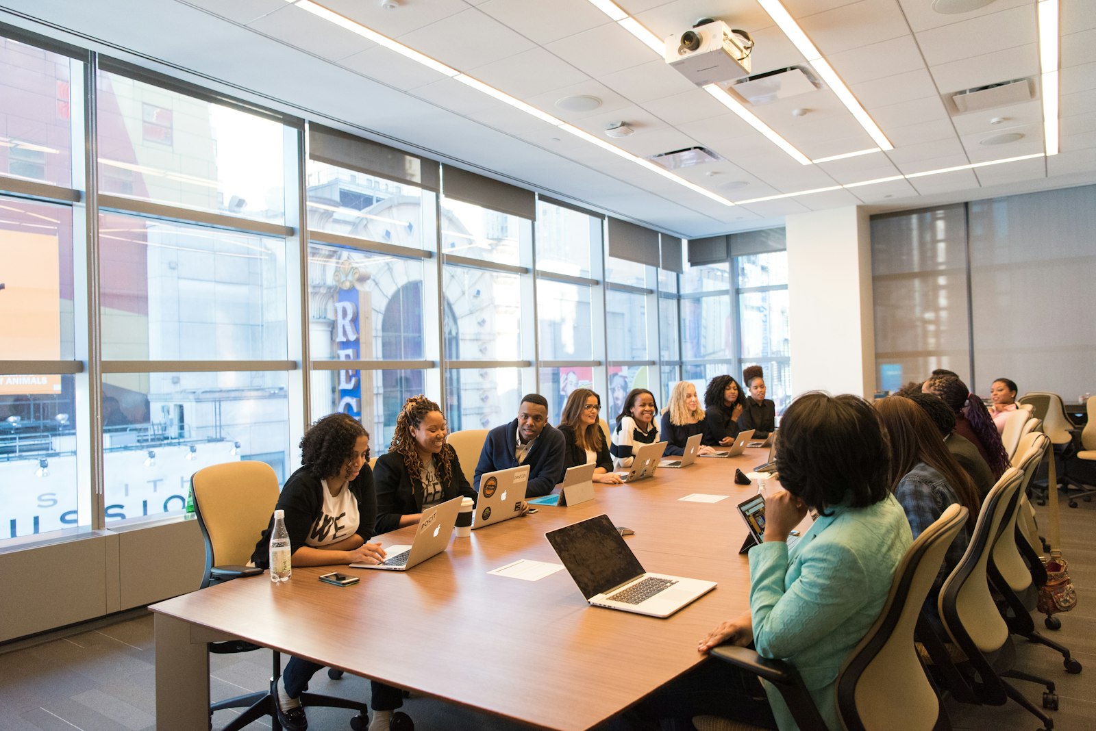 Diverse business team meeting in a bright modern conference room with laptops