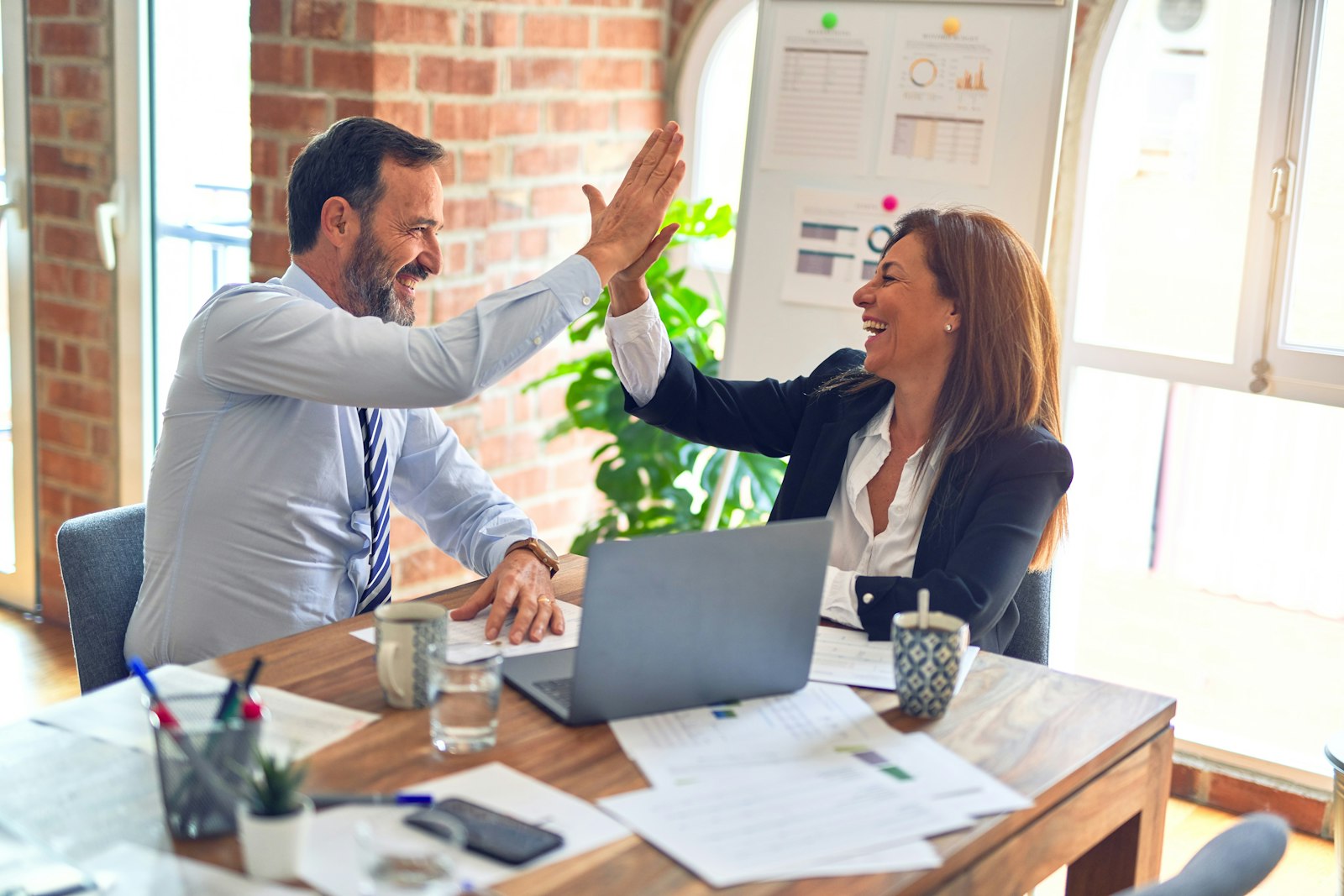 Two United Answering Service professionals celebrating a booked appointment together